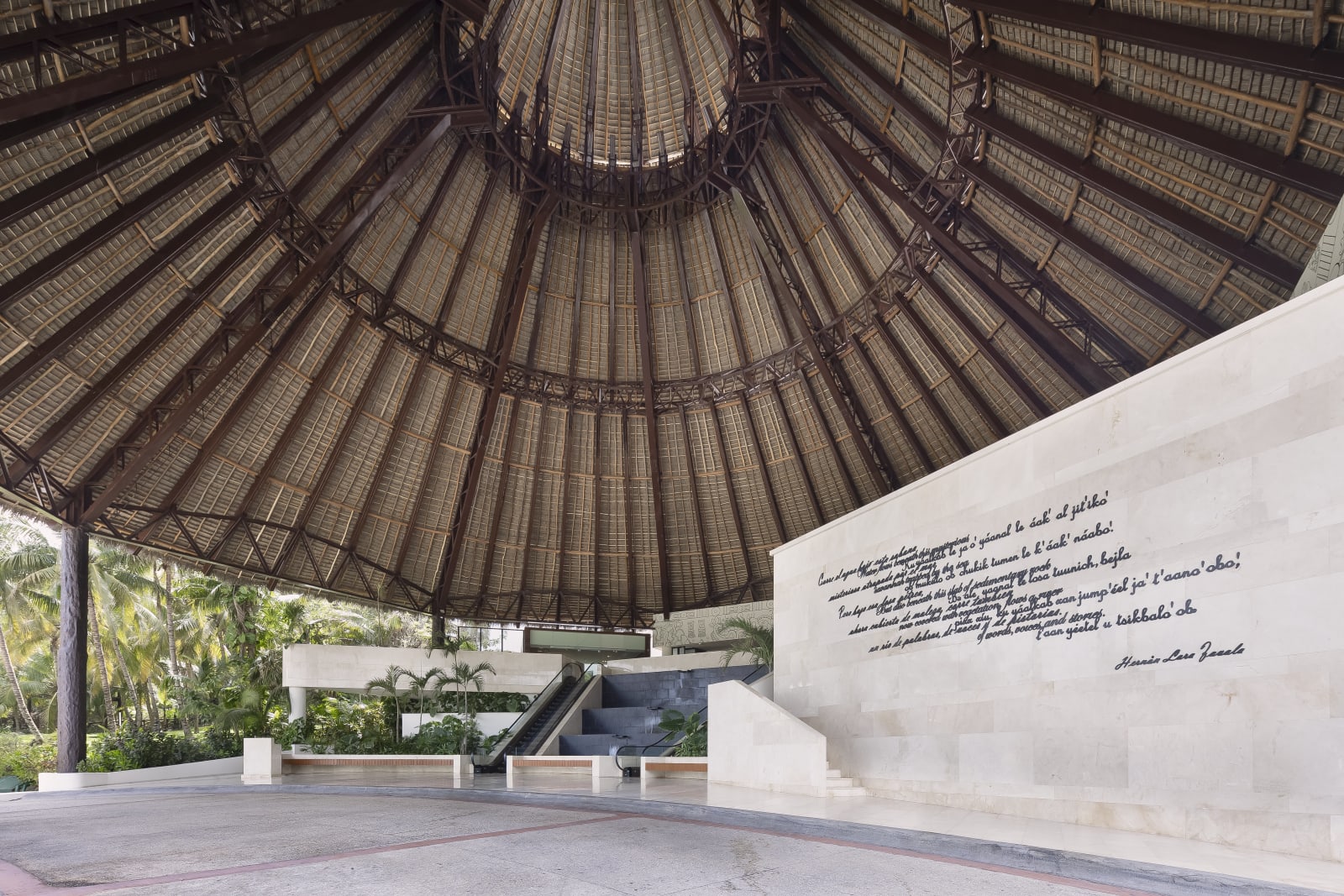 Soaring thatched palapa entrance and inscribed limestone wall at Fiesta Americana Condesa Cancún