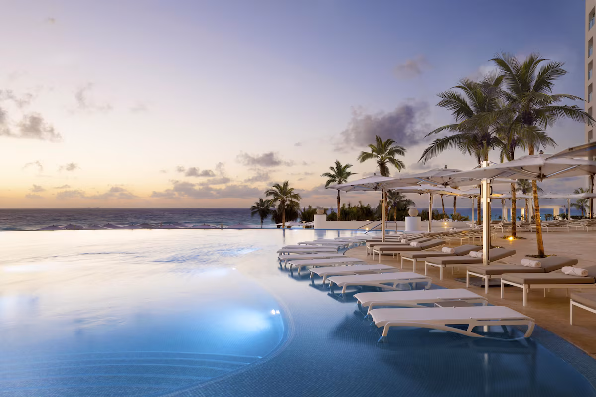 Oceanfront pool with umbrellas at Le Blanc Spa Resort Cancún